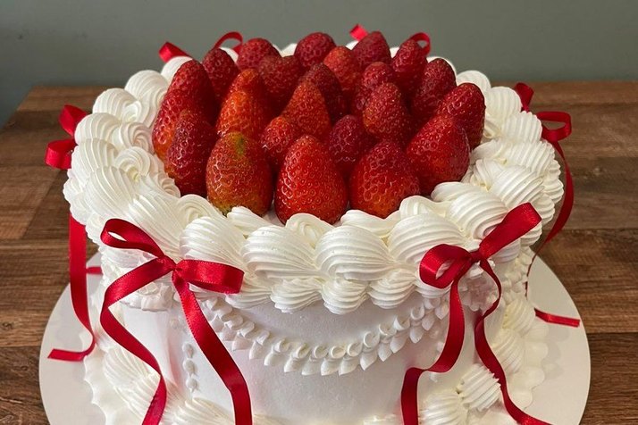 Bolo de morango com chantilly e laços vermelhos